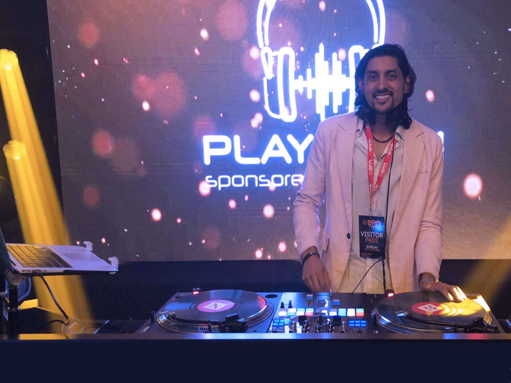 DJ SR video DJ set in front of a big screen at the BPM Show